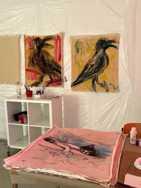 Two crows on the wall, a sleeping cat on the table