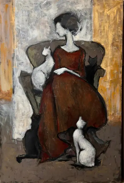 A woman in an armchair with white and black cats