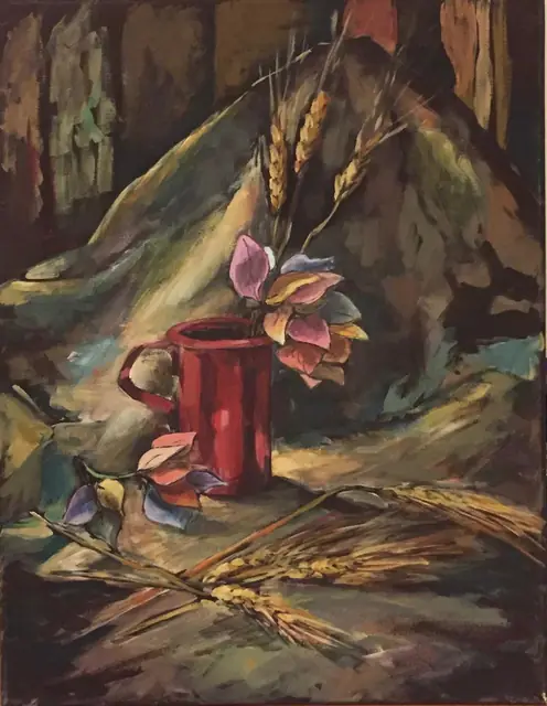 A red mug with dried leaves and wheat