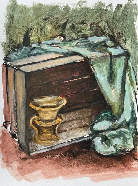 A brass vase beside a wooden crate draped in green cloth