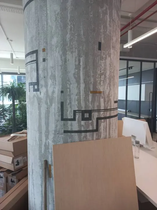 Kufic lines with touches of gold on raw concrete
