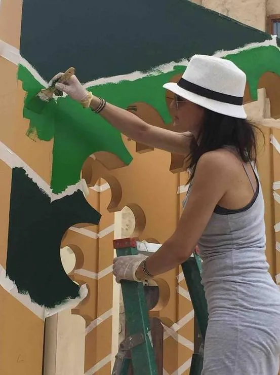 Rania painting the arches on site