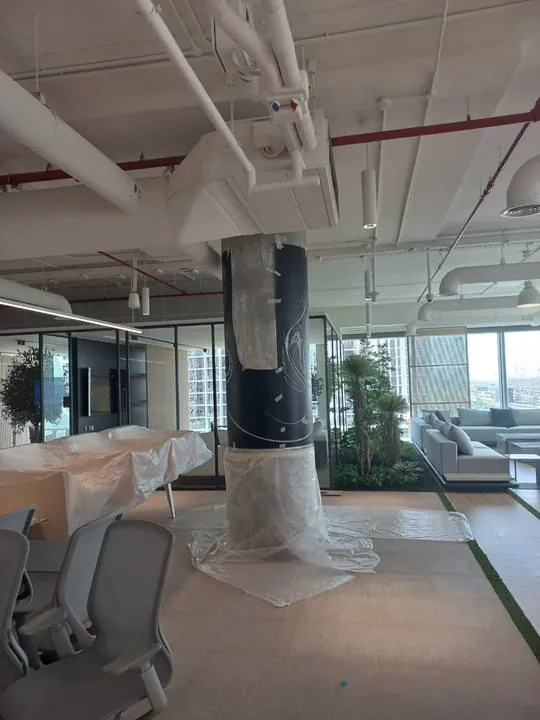 A column taking shape among the office plants
